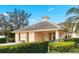 Exterior of the community clubhouse featuring a well-manicured lawn and hedges at 600 Mirabella Cir # 201, Venice, FL 34292