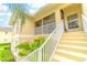 Exterior view of a condo featuring well-maintained grounds, staircase, and charming architectural details at 600 Mirabella Cir # 201, Venice, FL 34292
