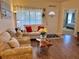Inviting living area featuring stylish furnishings, wood laminate flooring, and a glimpse into a comfortable bedroom at 600 Mirabella Cir # 201, Venice, FL 34292