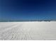 Wide sandy beach with clear blue skies and gentle ocean waves at 6006 Midnight Pass Rd # 48, Sarasota, FL 34242