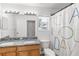 Well-lit bathroom featuring dual sinks, granite countertops, a toilet, and a shower with a decorative curtain at 6032 36Th E Ct, Ellenton, FL 34222