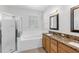 Bright bathroom featuring dual sinks, granite countertops, a soaking tub, and a glass-enclosed shower at 6032 36Th E Ct, Ellenton, FL 34222