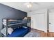Comfortable bedroom featuring a bunk bed, blue accent wall, closet, and warm wood floors at 6032 36Th E Ct, Ellenton, FL 34222