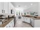 Spacious kitchen with white cabinets, granite countertops, stainless steel appliances, and an adjacent dining area at 6032 36Th E Ct, Ellenton, FL 34222