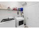 A clean, well-organized laundry room featuring modern washer and dryer units and ample storage shelving at 6032 36Th E Ct, Ellenton, FL 34222
