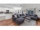Open-concept living room features a large, comfortable gray sectional couch, wood floors, and plenty of natural light at 6032 36Th E Ct, Ellenton, FL 34222