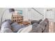 View of the living room with a comfortable gray sectional couch, entertainment center, and staircase in the background at 6032 36Th E Ct, Ellenton, FL 34222
