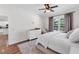 Neutral-toned main bedroom with a dresser, comfortable seating, a ceiling fan, and an area rug at 6032 36Th E Ct, Ellenton, FL 34222