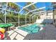 A screened in backyard pool is surrounded by brick pavers and lush landscaping, creating a private oasis at 6032 36Th E Ct, Ellenton, FL 34222