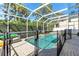 Enclosed swimming pool surrounded by lush landscape and a safety fence, with ample patio space at 6032 36Th E Ct, Ellenton, FL 34222