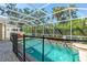 Enclosed pool features a secure safety fence, lush landscaping, and is surrounded by a brick paver patio at 6032 36Th E Ct, Ellenton, FL 34222