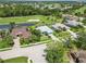 Aerial view of a neighborhood community on a golf course with mature trees and landscaping at 664 Planters Manor Way, Bradenton, FL 34212