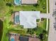 Birds eye aerial view of a home with screened lanai and pool surrounded by lush landscaping at 664 Planters Manor Way, Bradenton, FL 34212