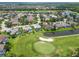 Scenic aerial of homes bordering a lush golf course, ponds, and community landscaping at 664 Planters Manor Way, Bradenton, FL 34212