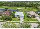 Aerial view of a neighborhood community on a golf course with mature trees and landscaping at 664 Planters Manor Way, Bradenton, FL 34212