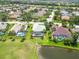 Expansive aerial view of beautiful homes with pools and screened enclosures in a lush, landscaped community with a pond at 664 Planters Manor Way, Bradenton, FL 34212