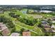 Sprawling aerial view of community with golf course, lakes, and verdant landscaping around luxurious homes at 664 Planters Manor Way, Bradenton, FL 34212