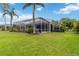 Beautiful backyard with a screened in lanai, lush landscaping and a well manicured lawn at 664 Planters Manor Way, Bradenton, FL 34212