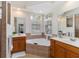 Well-appointed bathroom featuring a large soaking tub, double vanities, and arched windows at 664 Planters Manor Way, Bradenton, FL 34212