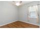 Neutral-toned bedroom with wood floors, ceiling fan, and large window with sheer curtains at 664 Planters Manor Way, Bradenton, FL 34212
