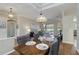 Charming dining area with a stylish chandelier and view of the adjacent living room at 664 Planters Manor Way, Bradenton, FL 34212