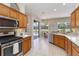 Well-lit kitchen with stainless steel appliances, wood cabinets, and view to the pool at 664 Planters Manor Way, Bradenton, FL 34212
