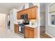 Kitchen with stainless steel oven and microwave, wood cabinets, and tile backsplash at 664 Planters Manor Way, Bradenton, FL 34212