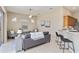 View of the living room with ceiling fan, sofa, side chairs, and kitchen with barstool seating at 664 Planters Manor Way, Bradenton, FL 34212