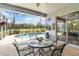 Screened-in patio featuring a dining table with views of the pool and golf course at 664 Planters Manor Way, Bradenton, FL 34212