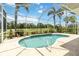 Inviting screened-in pool surrounded by tropical landscaping and palm trees, with golf course views at 664 Planters Manor Way, Bradenton, FL 34212