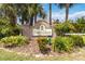 Community entrance signage surrounded by mature trees and lush tropical landscaping at 664 Planters Manor Way, Bradenton, FL 34212
