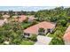 Expansive aerial view showcasing the red tile roof, mature landscaping, and well-maintained grounds at 706 Misty Pond Ct, Bradenton, FL 34212