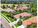 Aerial view of a neighborhood featuring well-maintained homes, lush landscaping, and a nearby golf course at 706 Misty Pond Ct, Bradenton, FL 34212