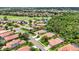 An aerial view showcases the neighborhood, golf course, and nearby houses with terracotta roofs at 706 Misty Pond Ct, Bradenton, FL 34212