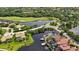 Aerial view of waterfront homes, private boat docks, and a golf course with ponds and lush green landscaping at 706 Misty Pond Ct, Bradenton, FL 34212