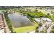 A scenic aerial view of a community lake with clubhouse, golf course, and parking amenities amid lush landscaping at 706 Misty Pond Ct, Bradenton, FL 34212