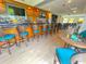 Stylish bar area with a wooden bar, a variety of liquor bottles, TVs, bar stools, and modern lighting at 706 Misty Pond Ct, Bradenton, FL 34212