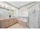 Bright bathroom featuring a double vanity, soaking tub, and a separate glass shower at 706 Misty Pond Ct, Bradenton, FL 34212