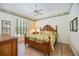 Well-lit bedroom with wooden furnishings, ceiling fan, and light hardwood floors at 706 Misty Pond Ct, Bradenton, FL 34212