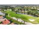 Scenic aerial view of the community golf course with pond, and homes with red tile roofs at 706 Misty Pond Ct, Bradenton, FL 34212