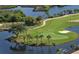 Breathtaking aerial image capturing golf course greens surrounded by a serene lake and swaying palm trees at 706 Misty Pond Ct, Bradenton, FL 34212
