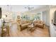 Spacious living room with laminate wood flooring and an open layout flowing into the dining area at 706 Misty Pond Ct, Bradenton, FL 34212