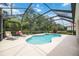 Inviting screened-in pool with a spa, surrounded by lush landscaping for a private backyard oasis at 706 Misty Pond Ct, Bradenton, FL 34212