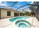Aerial view of a screened pool and spa with lush landscaping at 706 Misty Pond Ct, Bradenton, FL 34212