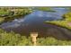 Scenic aerial view featuring a wooden pier, a large expanse of water, and lush greenery at 706 Misty Pond Ct, Bradenton, FL 34212