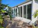 Enclosed back patio with sliding glass doors offers bright sunlight views of the backyard with tropical foliage at 730 Spanish S Dr # 99, Longboat Key, FL 34228