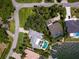 Aerial view of a home with a pool, lush landscaping, and waterfront access and dock at 7614 Peninsular Dr, Sarasota, FL 34231