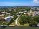 Aerial view of a boat launch and waterway, with lush tropical foliage and residential homes at 7614 Peninsular Dr, Sarasota, FL 34231