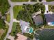 Aerial view of the property showcasing its expansive lawn, pool, and waterfront location at 7614 Peninsular Dr, Sarasota, FL 34231