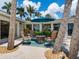 Covered patio with comfortable seating area for outdoor entertaining, surrounded by lush trees at 7614 Peninsular Dr, Sarasota, FL 34231